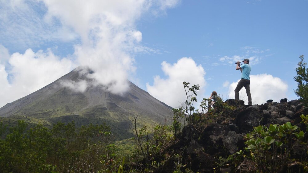 Man taking a photo of Arenal Volcano